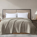 Overhead view of natural blanket in use, highlighting its generous size and fleece finish