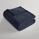 Navy blanket folded neatly, showing its plush teddy texture.
