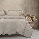 A beautifully made bed featuring a white duvet and pillows, exuding elegance and comfort in a serene bedroom setting