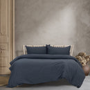 A cosy bed dressed in luxurious vintage washed navy blue sheets, perfect for a relaxing and stylish bedroom vibe.