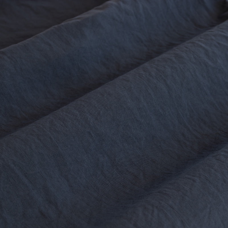 Close-up of a soft, navy fabric, perfect for creating a cosy and inviting bedroom atmosphere.