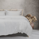 Serene bedroom scene with white sheets and pillows, highlighted by the soft Ardor Boudoir Vintage Washed White Quilt Cover Set.