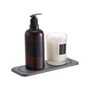 A soap dispenser adorned with a chic charcoal sink mat.