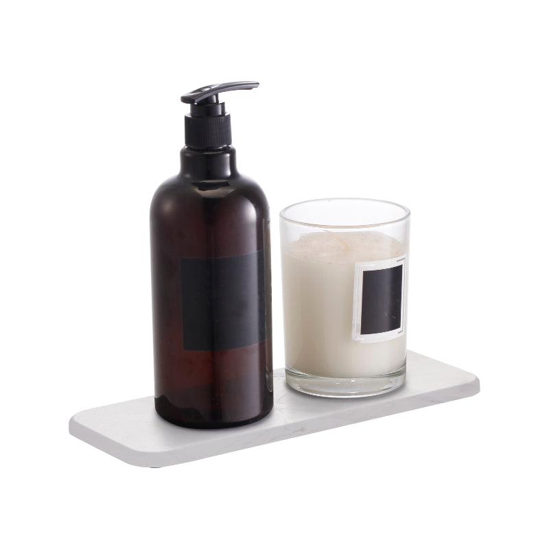 A soap bottle complemented by the functional white marble stone sink mat.