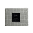 Front packaging of a cosy grey quilt cover set in a bedroom adding a touch of timeless elegance to the sleeping space.