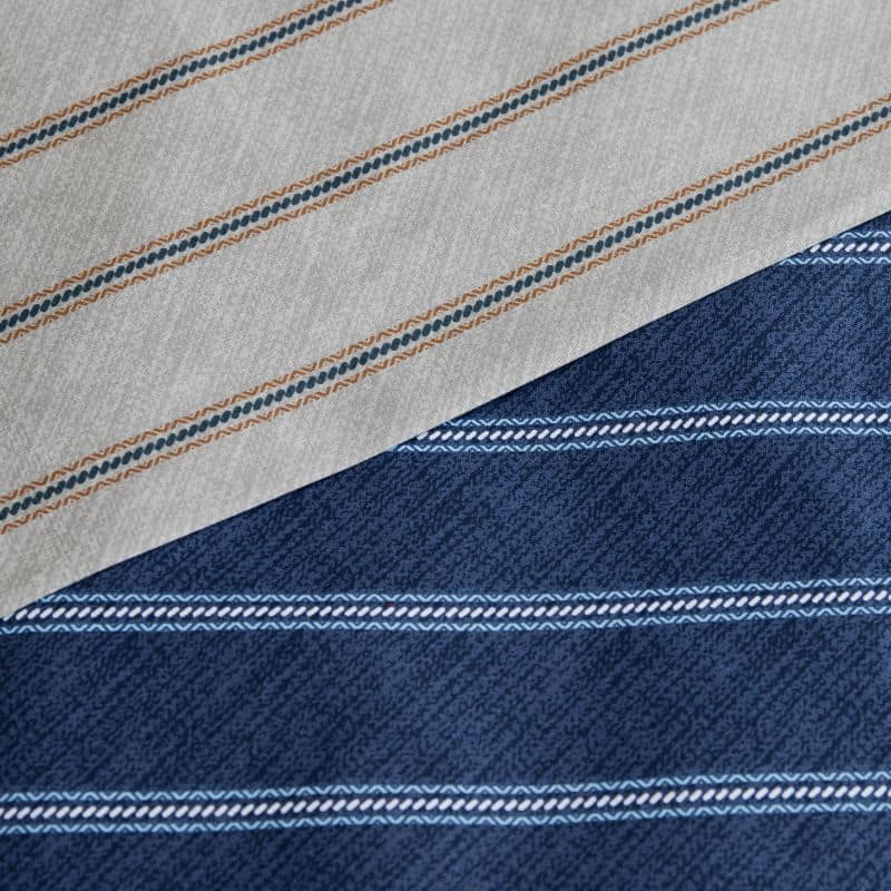 Close-up details of a deep navy quilt cover set with a grey striped design adds depth and sophistication to your space.