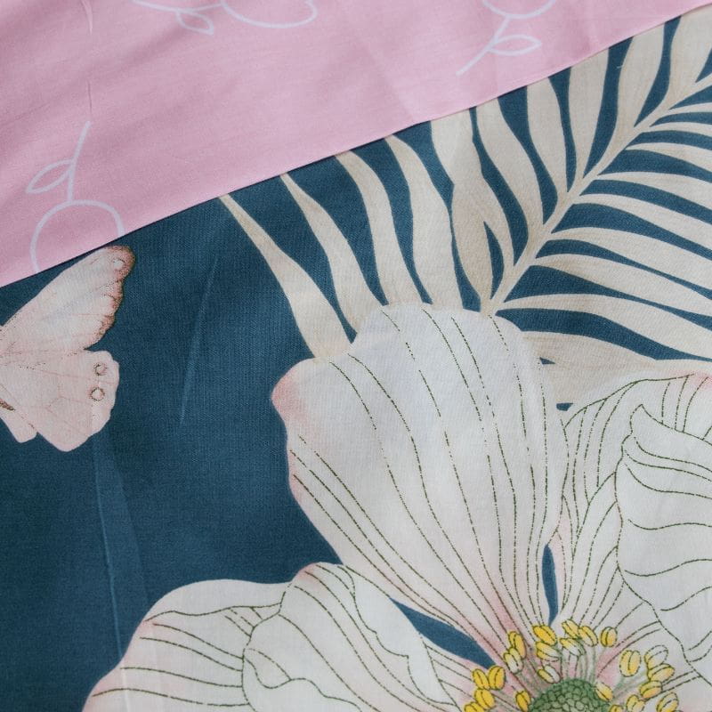 Close-up details of a tropical print bedding set with pink and blue flowers quilt cover set, brings warmth with ocean blue hues and delicate florals.