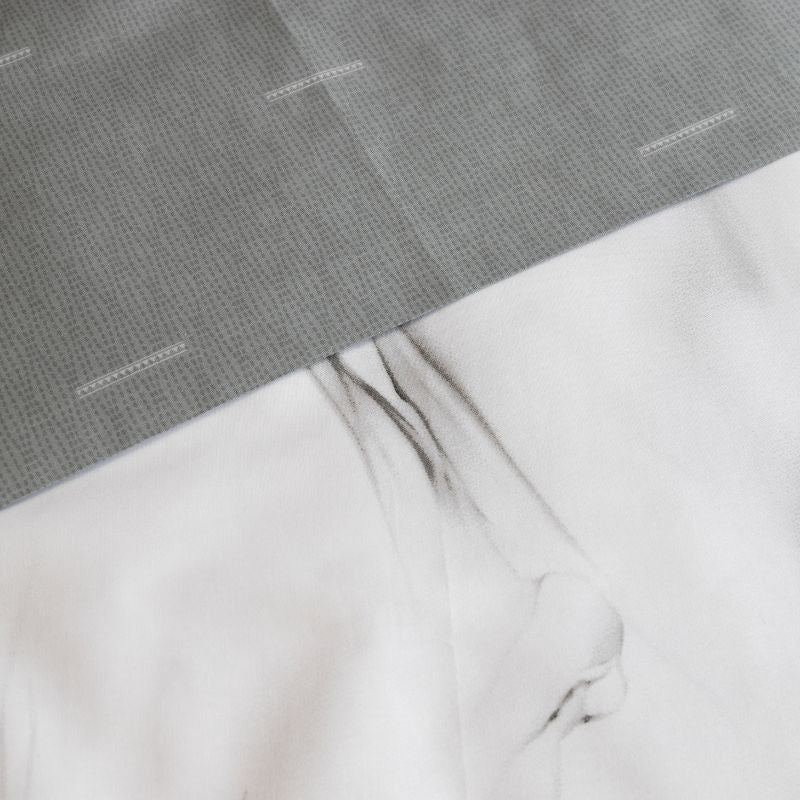 Close-up details of a soft flowing line work in shades of grey and black quilt cover set, adding dreamy movement to your space.