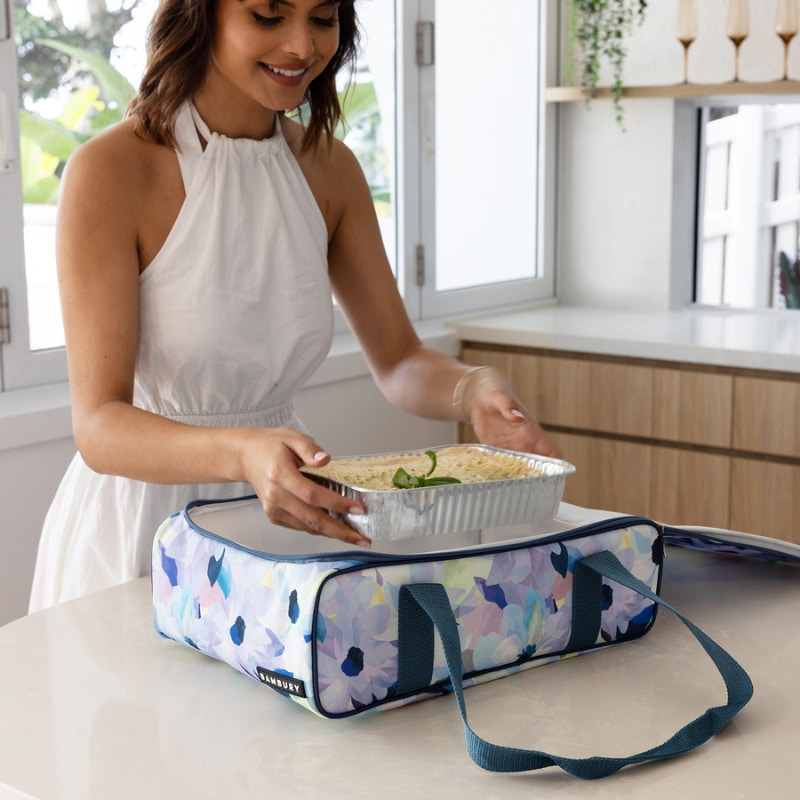 A woman packs a lunch, emphasising the practicality and elegance of the Bambury Ambrosia Blue food carrier.