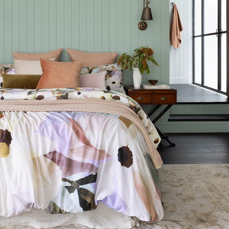 A quilt cover set featuring watercolour flowers in stunning earthy and pastel tones with a reversible design: one side showcases large flowers, while the other side features smaller blooms, providing the option of two different looks.