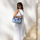 A woman in a white dress, emphasising a fashionable Ambrosia cooler bag for food and drinks.