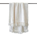 Full view of white throw hanging from a rail with check pattern visible