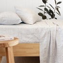 Bambury Bowie Flannelette Sheet Set styled on a wooden bed with matching pillowcases in a soft neutral geometric pattern