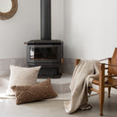 Alt="A brown cotton yarn woven diamond pattern rectangular cushion on the floor in a bohemian-themed living space"