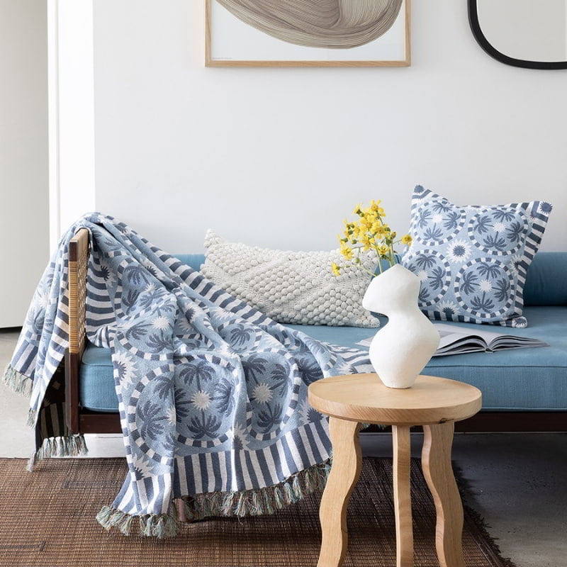 alt="An ivory cotton yarn woven diamond pattern rectangular cushion on a sofa in an artistically inspired living space"