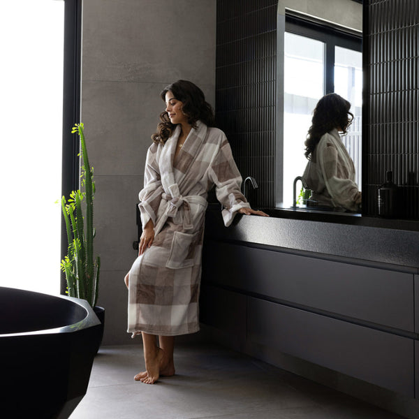 Woman wearing the Bambury Charlie Ultraplush Robe in a modern bathroom, showing off its cosy fit and stylish check pattern