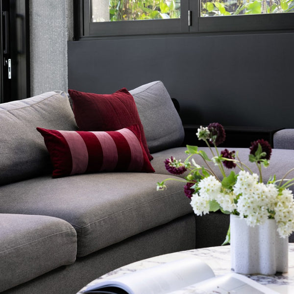 Bambury Copper Berry Cushion styled on a grey lounge with coordinating cushions