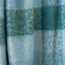 Detail view of an aqua and green check pattern of the Cosmo Throw captured in soft natural light

