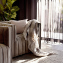 Bambury Cosmo Stone Throw draped casually over a sofa in a styled living space
