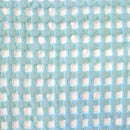 Close-up image of a blue and white fabric, emphasizing the exquisite texture of the reversible Dora Aqua Throw.