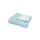 A folded Dora Aqua Throw, emphasizing its sumptuous waffle texture and reversible elegance for decor.