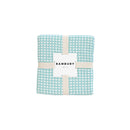 The Dora Aqua Throw packaging, highlighting its luxurious fabric and stylish appearance.