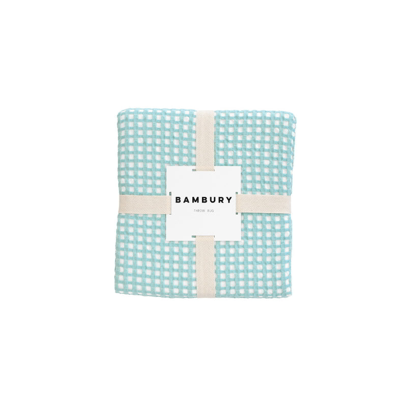The Dora Aqua Throw packaging, highlighting its luxurious fabric and stylish appearance.