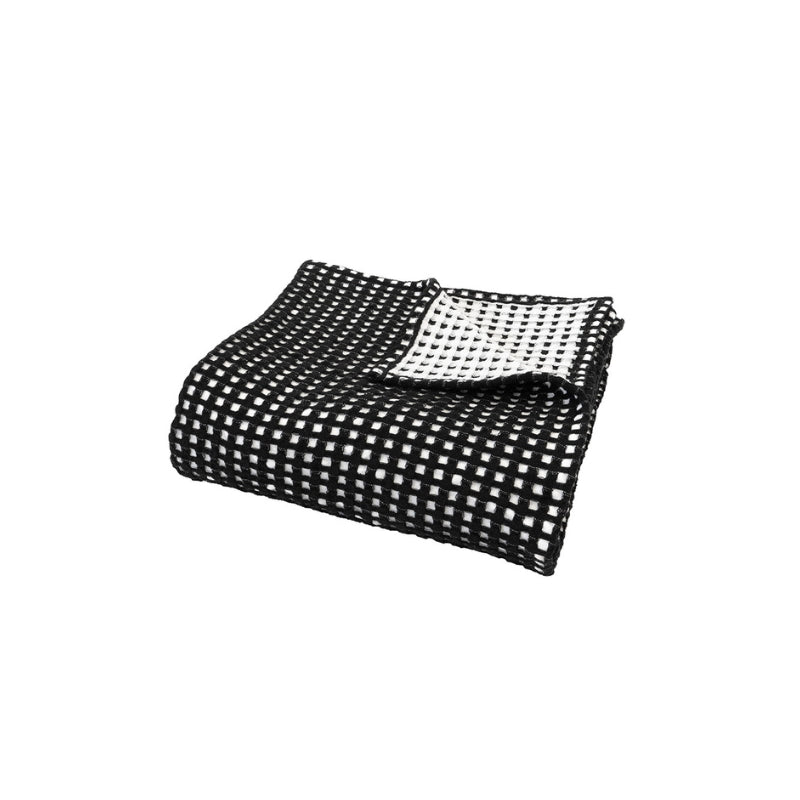 Stylish folded Dora Black Throw, crafted from waffle fabric, offering versatility and sophistication for home styling.
