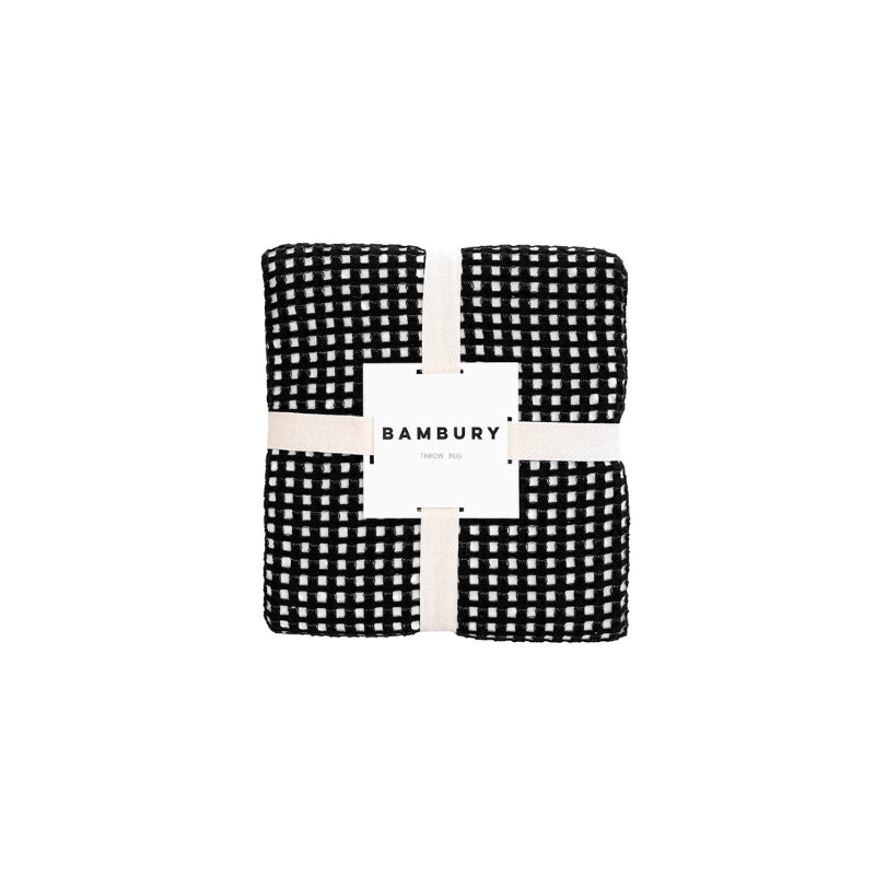 A Dora Black Throw packaging, emphasizing its sophisticated design and appealing contrast.