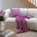 A stylish couch with Dora Orchid Pink Cushion, highlighting the sophisticated texture ideal for stylish home interiors.