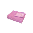 Elegant folded Dora Orchid Throw, showcasing reversible two-toned waffle fabric for versatile home decor.