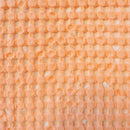 A vibrant Dora Peach Throw, crafted from rich waffle fabric, ideal for enhancing the aesthetic of your home decor.