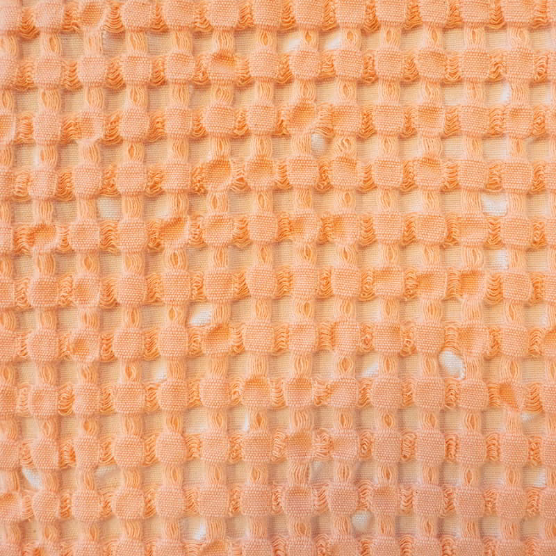 A vibrant Dora Peach Throw, crafted from rich waffle fabric, ideal for enhancing the aesthetic of your home decor.