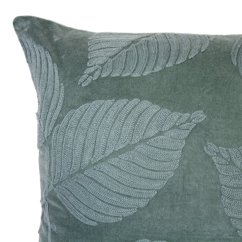 alt="Close-up view of a green velvet cushion designed with eucalyptus leaves"