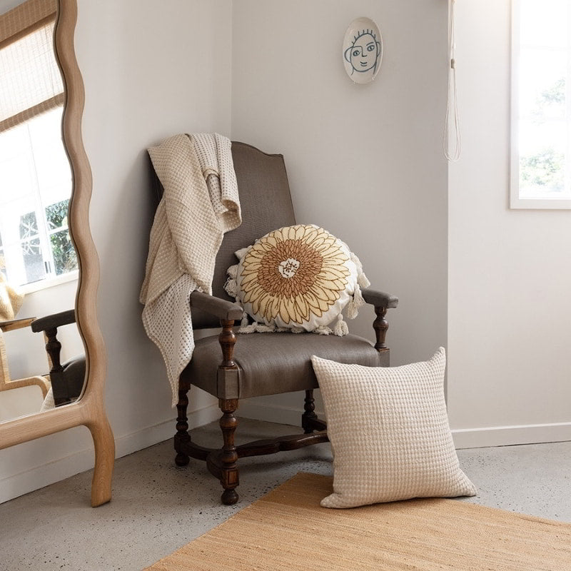 alt="Two-toned natural throw with a beautiful waffle texture in a bohemian-theme living space"