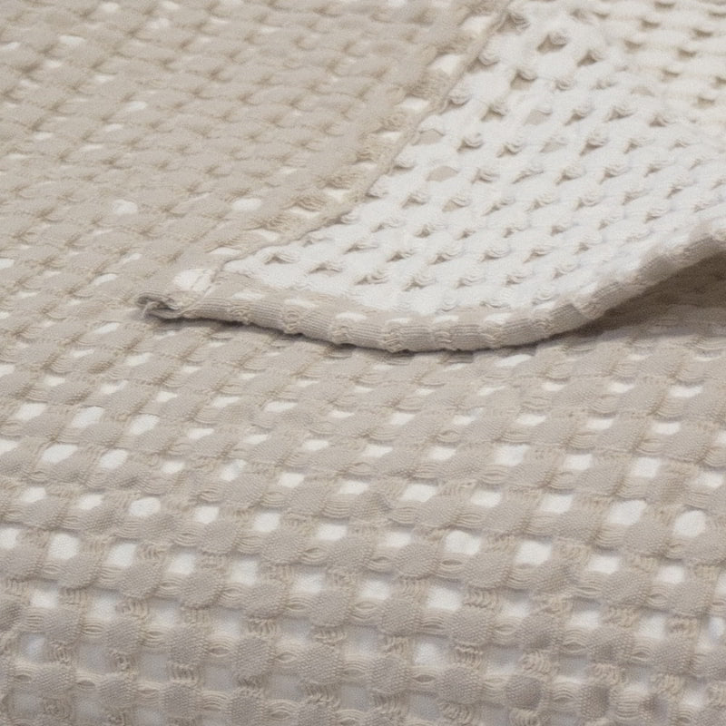 alt="Close-up view of a two-toned natural throw with a beautiful waffle texture"