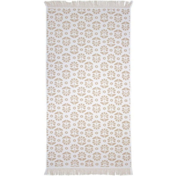 alt="Natural beach towel designed with floral pattern and tassels on both ends"