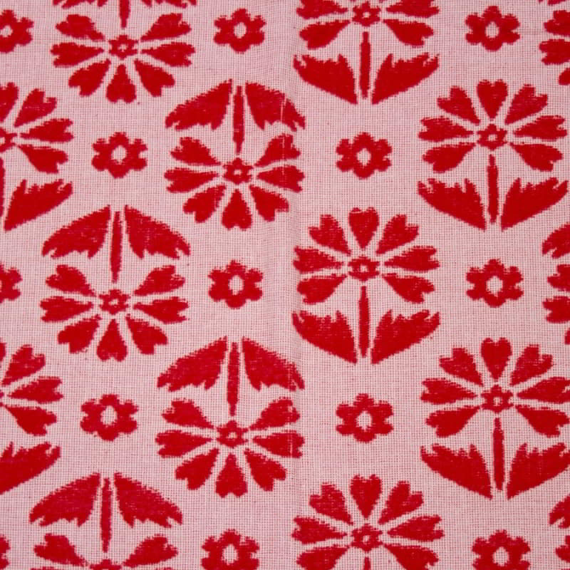 alt="Close-up view of a red beach towel designed with floral pattern and tassels on both ends"