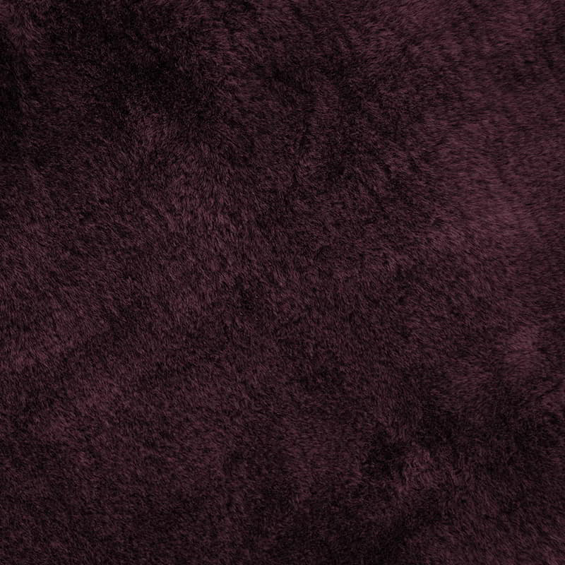 Detailed shot of a square maroon cushion made of soft faux fur fabric, perfect for adding extra comfort and warmth to your couch or bed. Machine washable.