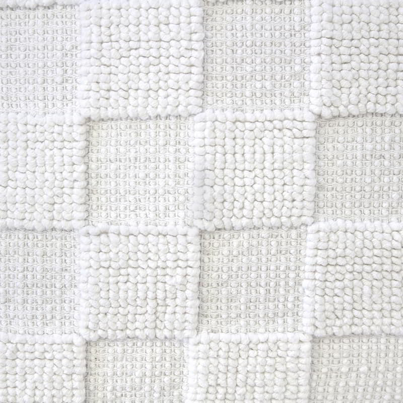 Detailed shot of a sophisticated ivory cushion made from 100% cotton with checkerboard pattern. Features removable fill, machine washable for easy care.