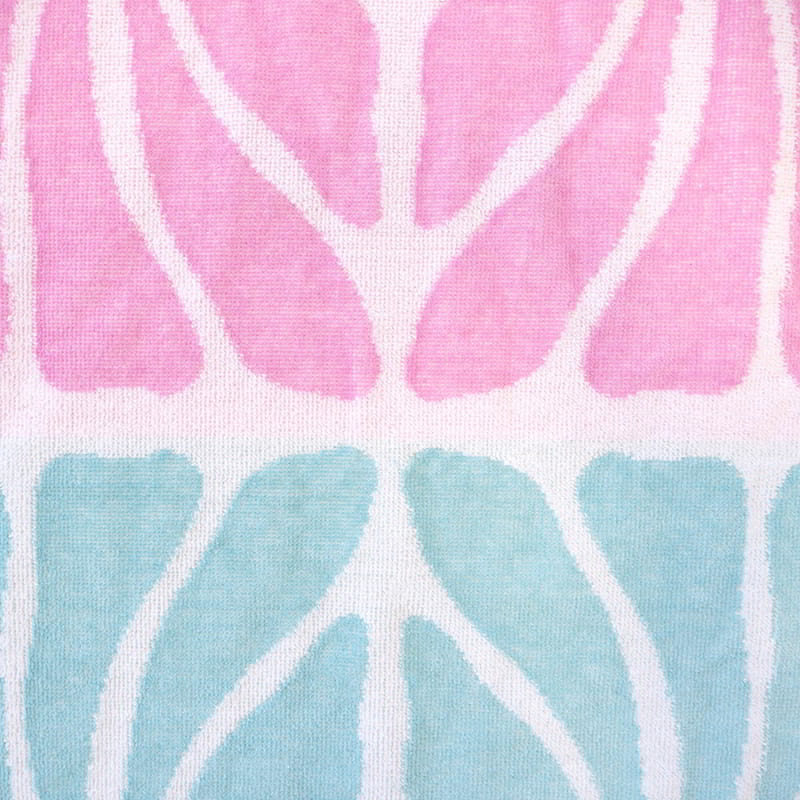 Detailed view of a stylish pink and blue beach towel, featuring a plush texture and intricate jacquard pattern for ultimate comfort.