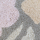 Close-up of soft looped embroidery in neutral and pink tones

