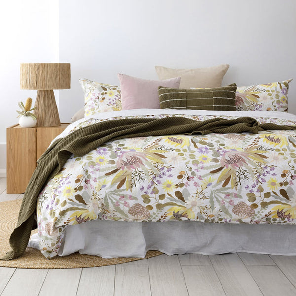 alt="A hand-painted, digitally printed quilt cover set designed with a smaller scale floral print on the reverse inspired by the striking foliage of Australian flora in a botanical-theme bedroom"