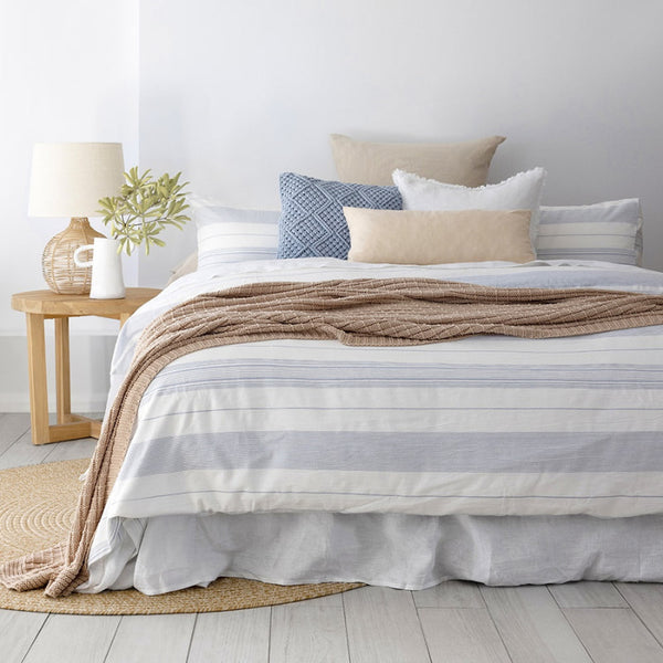 alt="A versatile stripe quilt cover set designed with a clean white base and nautical blue woven stripes in a classic coastal feel bedroom"