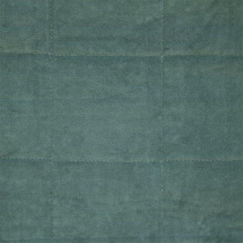 Detailed view of a  luxurious green cushion features gorgeous cotton velvet with quilted square pattern.