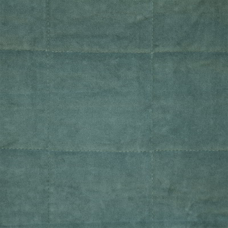 Detailed shot of a green cotton velvet throw with quilted square pattern, coordinating cushion available and, machine washable.