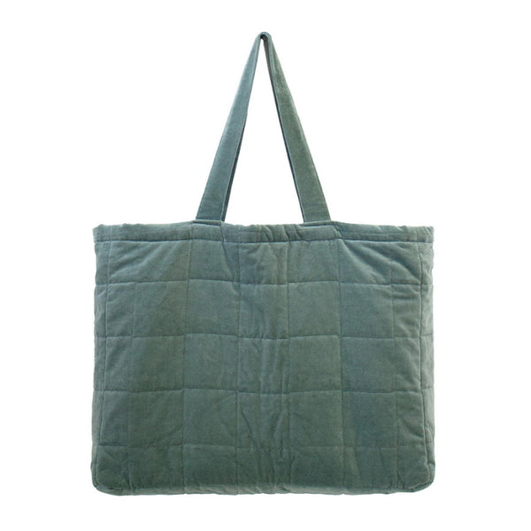 A large green tote bag made from sumptuous cotton velvet featuring a quilted square pattern, cotton lining, and a pocket.