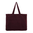A large burgundy tote bag made from sumptuous cotton velvet featuring a quilted square pattern, cotton lining, and a pocket.