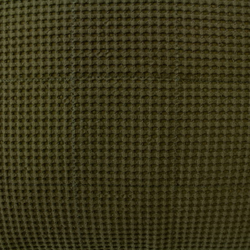 Detailed shot of our olive green bedding set, made from soft cotton waffle fabric with a quilted square design.