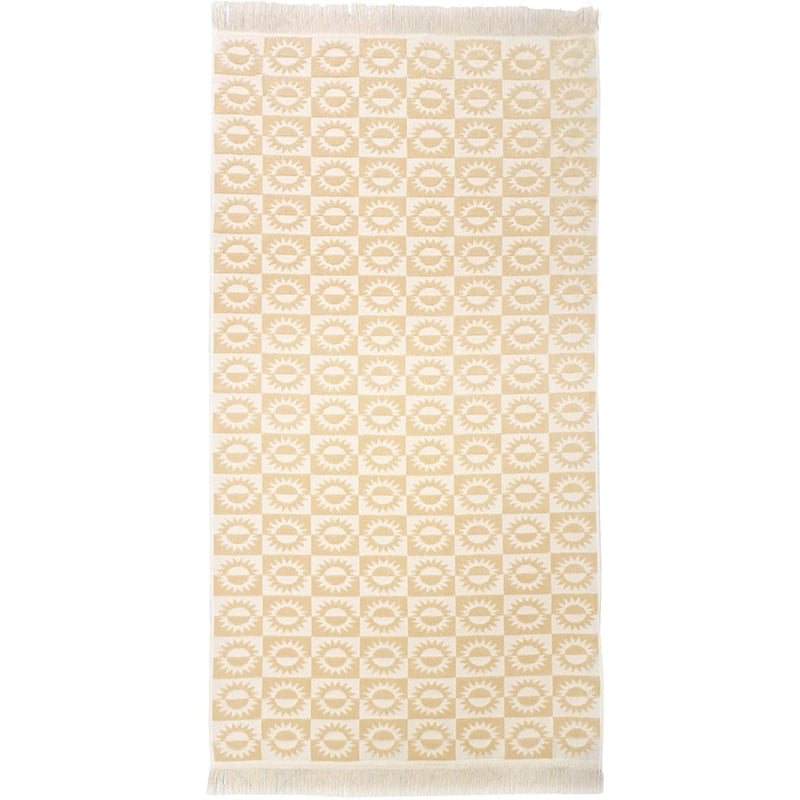 alt="A yellow beach towel featuring a stylish sun pattern with knotted tassels on both ends"